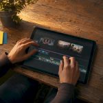 Hands editing vintage film strips on wooden table