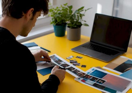 Hands manually cropping film strip on wooden table