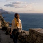 Traveler walking coastal path at dusk