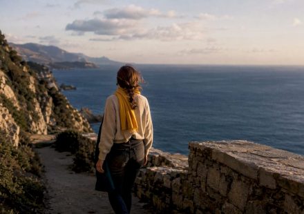 Traveler walking coastal path at dusk