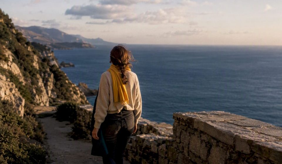 Traveler walking coastal path at dusk