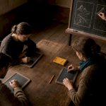 Students preparing lesson notes in an old classroom